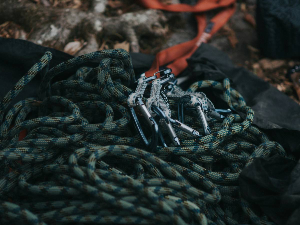 Climber testing crack stopper tools set in narrow offwidth crack