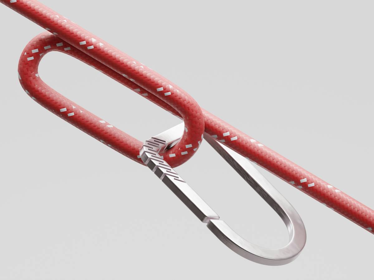 Hex climbing carabiner clipped to a steel hex placed in a granite crack