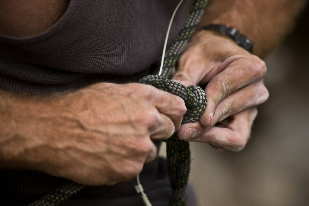 Climber placing a hex with a hex climbing strap in a granite crack